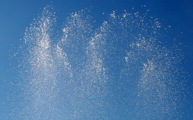 Water splashing from the fountain in the background of blue sky