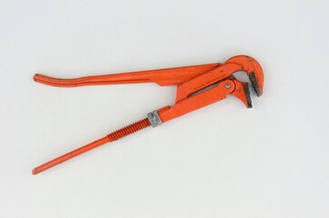 adjustable orange wrench on white background, repair tool