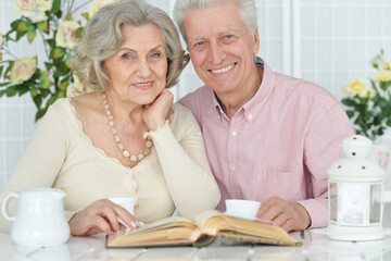 Portrait of happy senior couple reading book