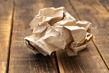 A crumpled sheet of craft paper on a wooden table.