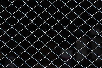 Naklejka premium Close up metal net fence in square shape with abstract dark background can be use for security company product advertisement website template and content creator