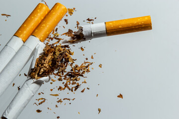 Broken cigarette fly in air on a light background. Conception of combating smoking