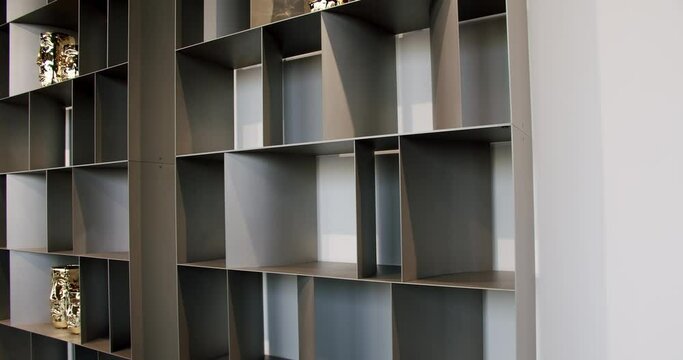 Shelves with home stuff. Indoor minimalist furniture. Minimalist black shelf, Modern Furniture and cozy design. Home modern black shelf. Nice designed modern interior of the living room furniture.