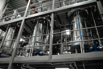 Industrial stainless steel vats. Factory interior, steel pipelines, tubes. Equipment for the...