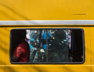 A passenger is seen in a yellow danfo bus through the window in Lagos, NIGERIA, April 29 2022.