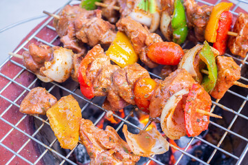 Barbecue skewers meat with vegetables on grill close up