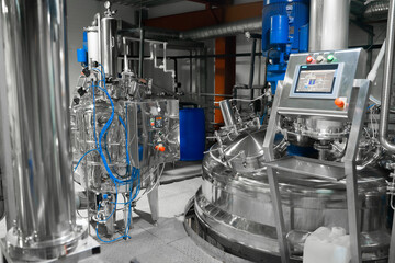 Equipment control station. Factory interior, steel pipelines, tubes. Equipment for the production of organic fertilizers. 