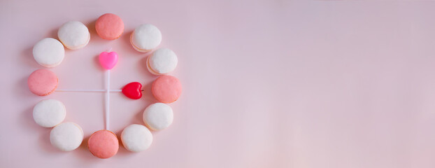 Banner Creative clock made of macaroons on a pink background