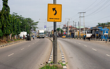 A road sign shows that there is a bend ahead in  Lagos