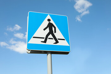 Traffic sign Pedestrian Crossing against blue sky, low angle view
