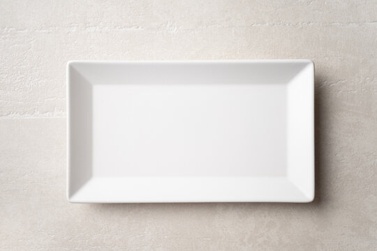 Rectangular white plate on a light stone background, the concept of food, restaurant