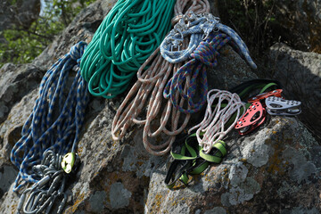 Different ropes and other climbing equipment on rocks outdoors