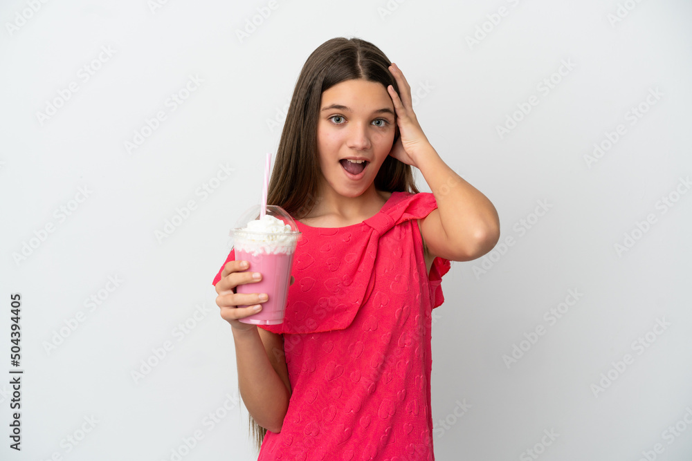 Wall mural Little girl with strawberry milkshake over isolated white background with surprise expression