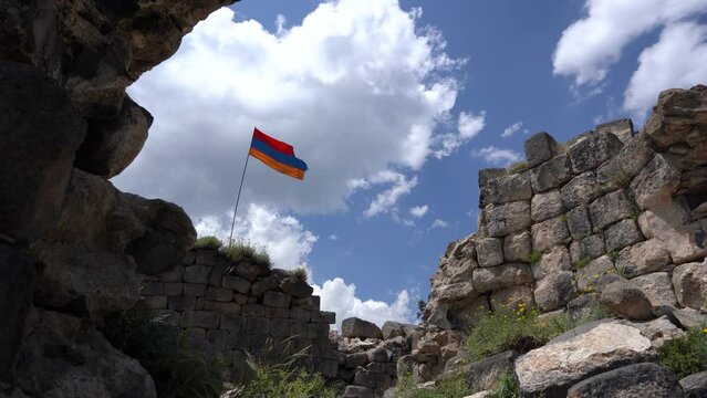 Ruins of Amberd in Armenia. Armenian  flag on sky.  Medieval castle ruins in fortress Amberd in Armenia, Caucasus. 