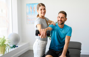 Obraz premium Modern rehabilitation physiotherapy woman worker with man client