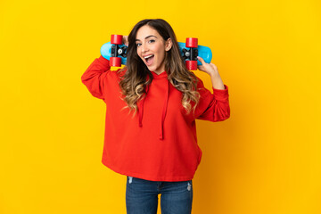 Young caucasian woman isolated on yellow background with a skate