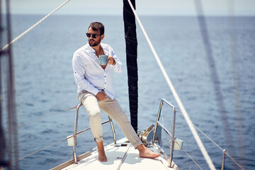 Casual attractive man sailing alone; Luxurious lifestyle concept - 504397844