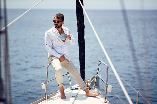 Casual attractive man sailing alone; Luxurious lifestyle concept