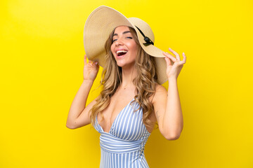 Young caucasian woman isolated on yellow background happy in swimsuit in summer holidays