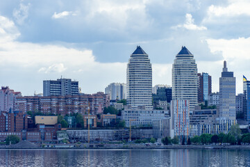 Panoramic view on the central part Dnipro city and river bank in the Ukraine. Urban landscape with shopping centers, business offices and high-rise apartments. Beautiful embankment against the sky. 