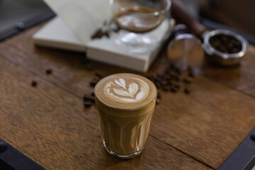 cup of coffee latte art put on  barista wooden table.