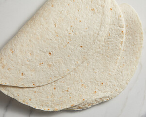 Plain tortilla wrap on white background from above.