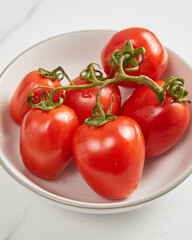 Overhead view of fresh tomato in white bowl