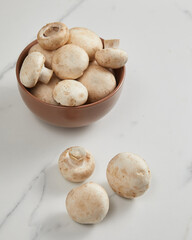 Overhead view of champignon mushrooms in brown bowl