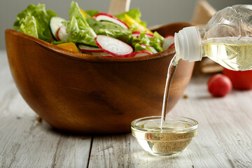 Close up view of pouring soy oil into glass little bowl 