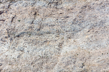 Grey rock background texture. Stone formation, rough natural material shaped by the sea, salt wind