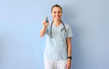 Smiling young inhalotherapy woman with stethoscope holding asthma pump
