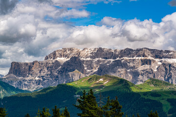 View of Italian Dolomite Mountain at the Alpine Green Plateau Seiser Alm with blue sky and white clouds in South Tyrol, Italy