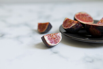 cut figs on a black plate.