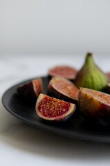 cut figs on a black plate.