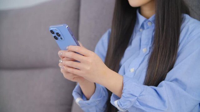 Asian girl using phone. Young Vietnamese female person typing a message on a smartphone