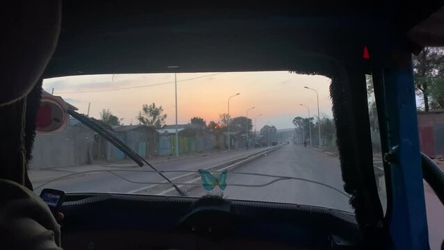 Bajaj three-wheeler taxi interior in the early morning driving in empty street.