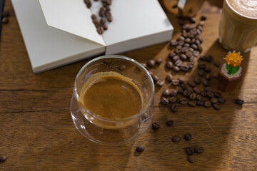 clear cup of coffee put on brown wooden table.