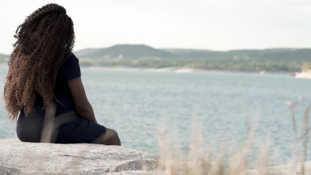 woman sitting on the edge of the river