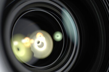 Detailed camera lens on a dark paper background. Light reflections in glass lenses.