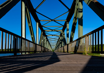 Obraz premium Old steel bridge over Ruhr river at “Baldeneysee“ in Essen Germany. Nostalgic former railway bridge from Kupferdreh to Heisingen with symmetric rivet construction today is for pedestrians and bikers. 