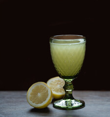 Fresh lemon juice in beautiful glass with green apples near and black background. High quality photo