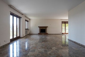 Front view empty living room with fireplace. Interior of empty old villa to be refurbished