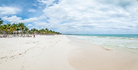 Panorama over a tropical beach taken from the water during the day with sunshine