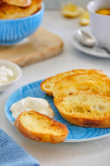 Crushing slices of baguette on a plate with a cup of tea.