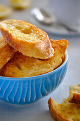 Crushing slices of baguette on a plate with a cup of tea.