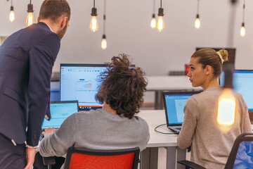 Beautiful blond and a coworker with afro haircut working in modern start up offices. Businessman...