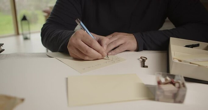 Writing a letter with a ballpoint pen. The camera moving from right to left around the action