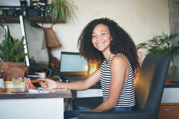 Confident young businesswoman smiling in her home office