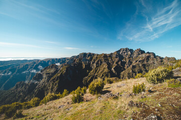 Views of the island of Madeira from the highest mountain, Pico Ruivo. Adventure on a small island in the Atlantic Ocean. Green vegetation turning into a rocky surface. Portugal treasure