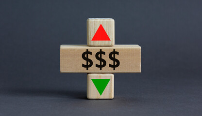 Dollar rates symbol. A wooden cube with arrow symbolizing that dollar rates are going down or up. Beautiful grey table grey background. Business and dollar rates concept. Copy space.